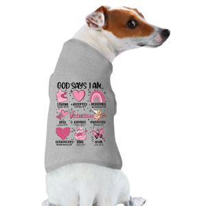 A small dog wears the "Valentine's Day Funny Shirt: God Says You Are," a gray shirt featuring colorful illustrations, uplifting words like âStrong,â âAccepted,â and Bible verse referencesâan ideal Valentineâs Day pet clothing choice.